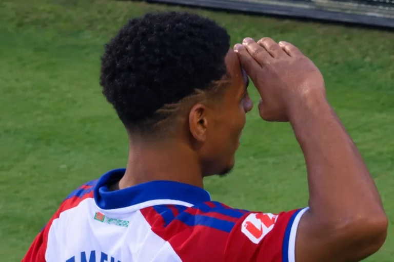Emeka del Granada in maglia a strisce rosso-blu osserva il campo