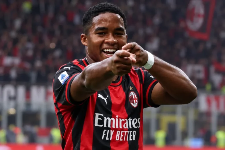 Endrick in maglia rossonera con Emirates Fly Better sorride e indica verso la telecamera durante una partita