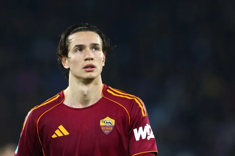 Ghilardi con la maglia della Roma, stemma giallorosso in evidenza, sguardo rivolto in alto durante una partita