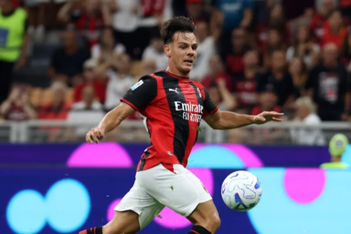 Jashari in azione con la maglia rosso-nera del Milan, sponsor Emirates, durante una partita davanti al pubblico