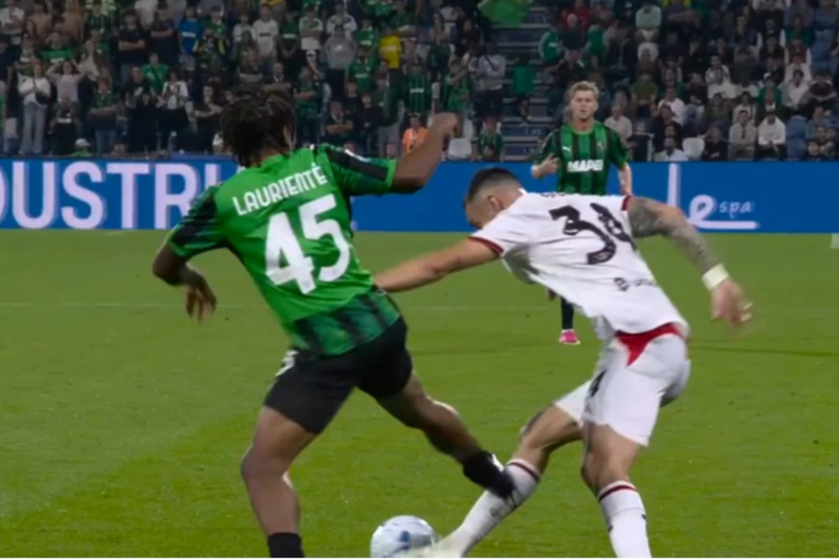 Lauriente del Sassuolo, numero 45 di maglia verde, contrasta un calciatore del Milan con la maglia bianca numero 38 durante u