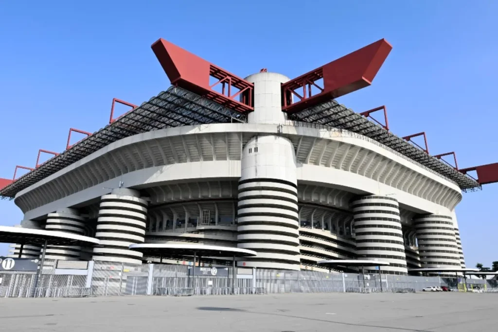 Stadio San Siro di Milano con struttura bianca e nera, coperture rosse e piloni caratteristici
