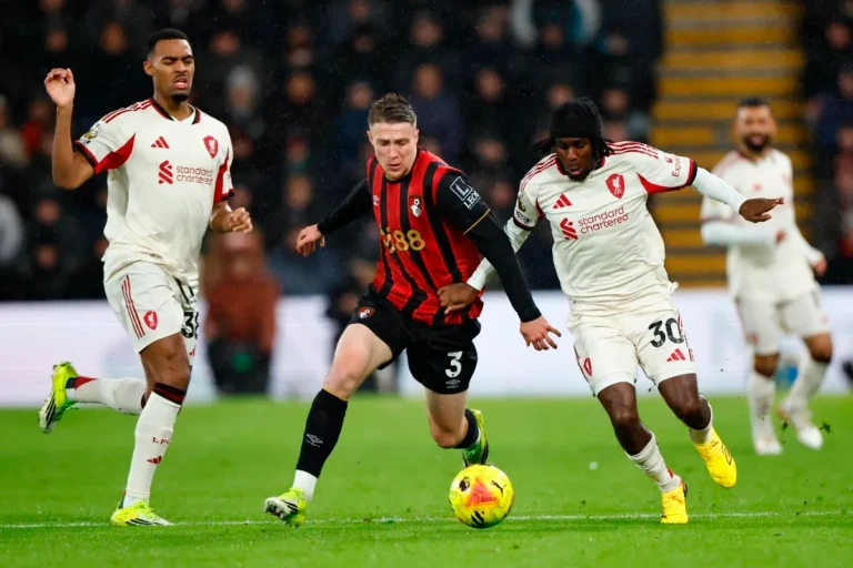 Truffert in azione con la maglia del Bournemouth contro i difensori del Liverpool in Premier League